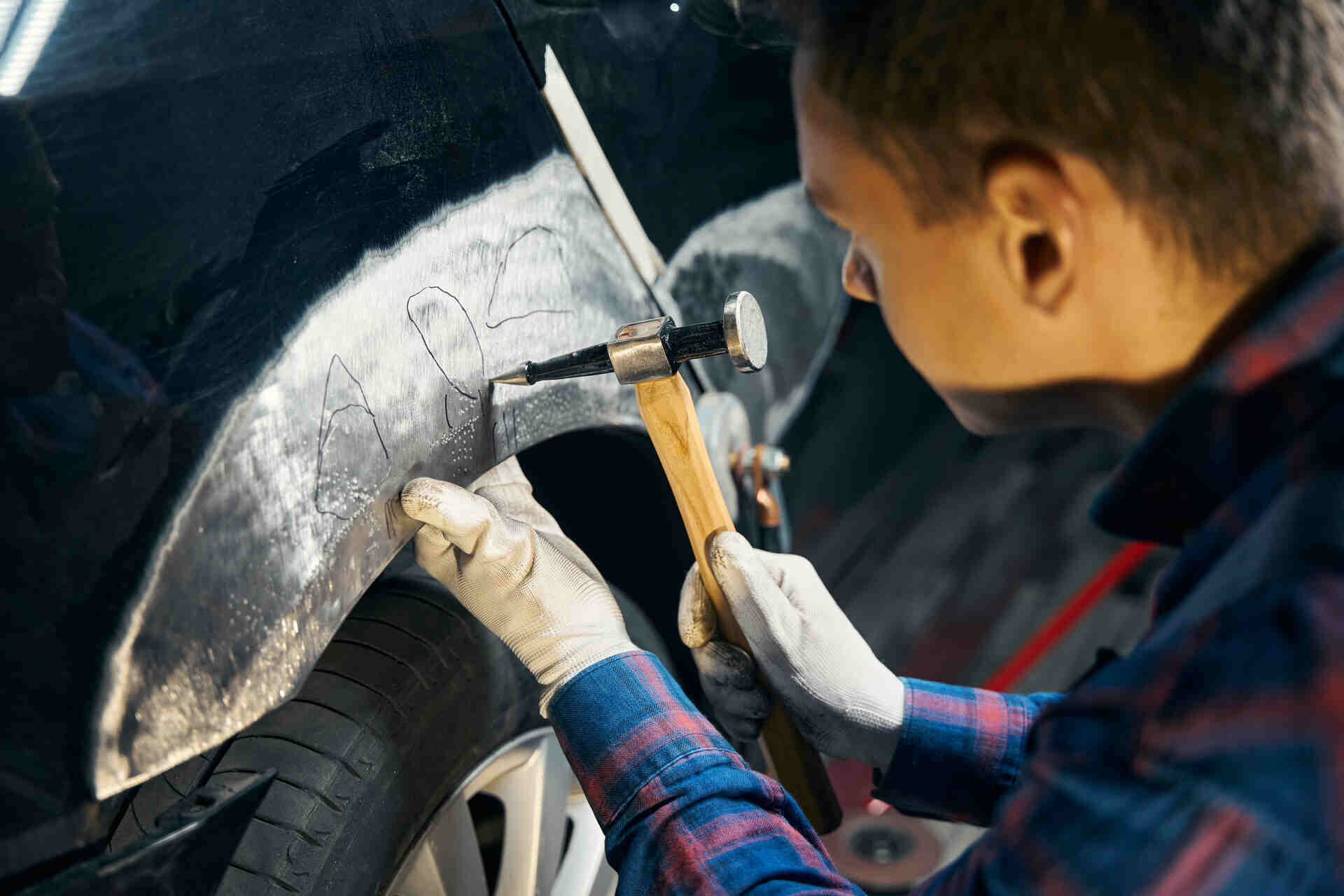 Mechanic repairing a fender on a car in NJ